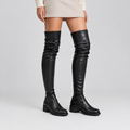 Black over-the-knee boots worn by a model
